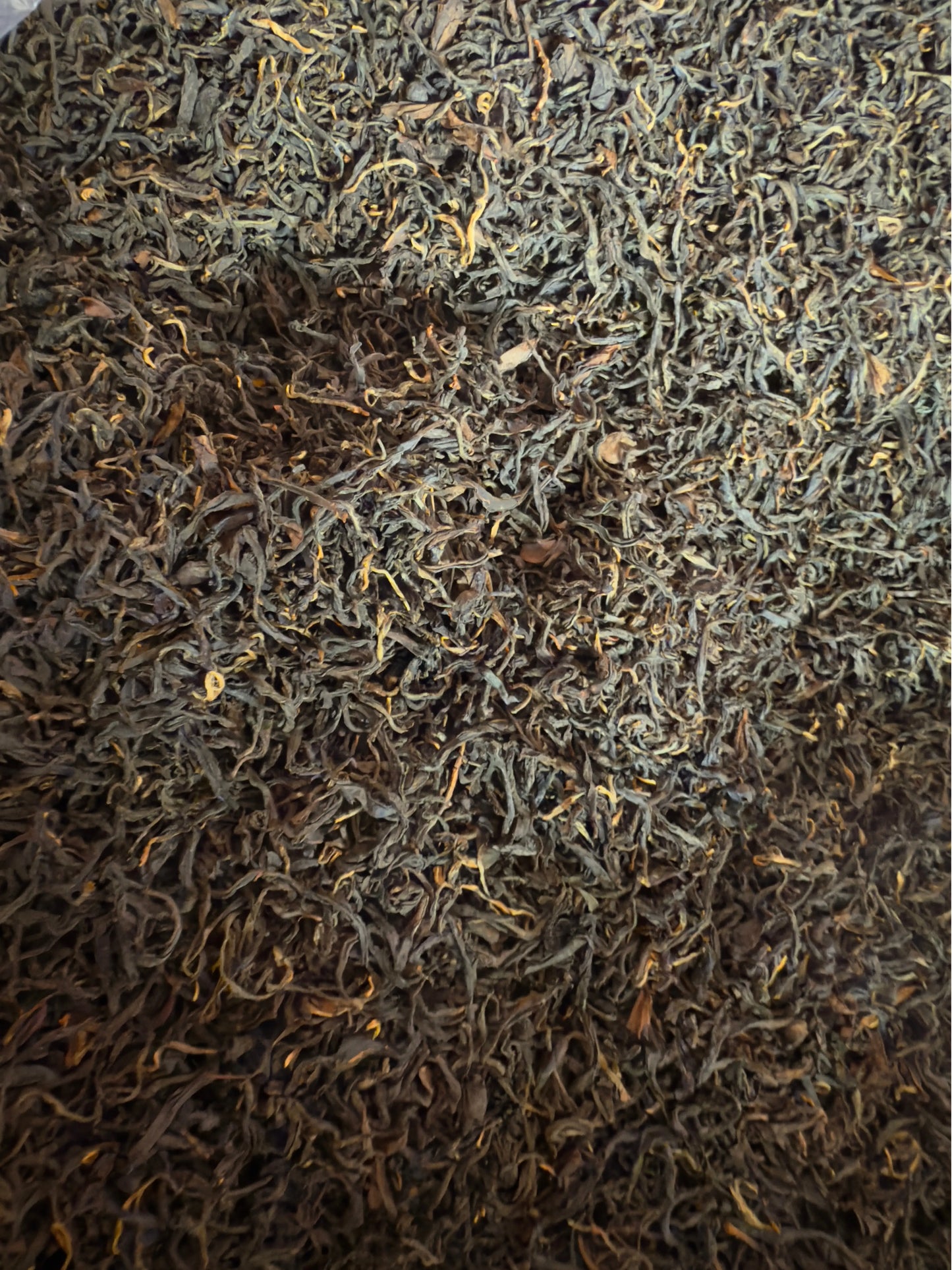 Close-up of dark brown and green tea leaves.