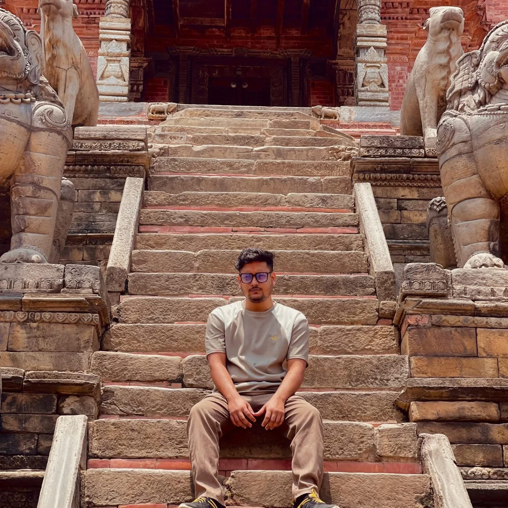 Technical manager of viorhana sitting on stone steps with classical architecture in the background