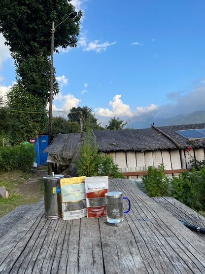 Soma silver and white Tea packaging and a mug on a wooden table with a scenic background
