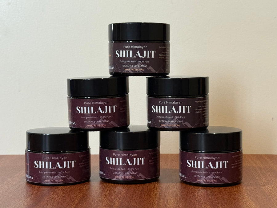Stack of Shilajit containers on a wooden surface with a neutral background