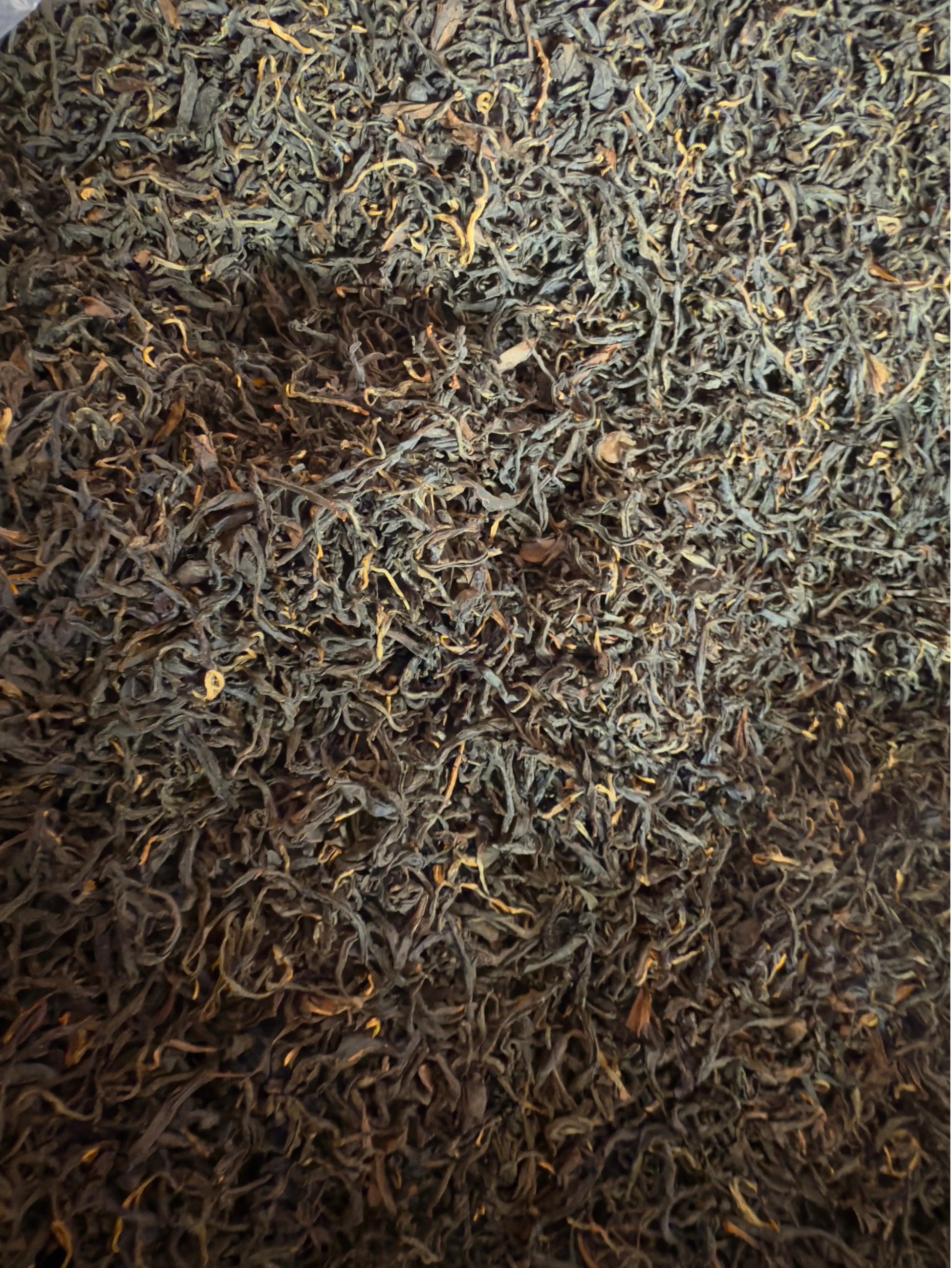 Close-up of dark brown and green tea leaves.